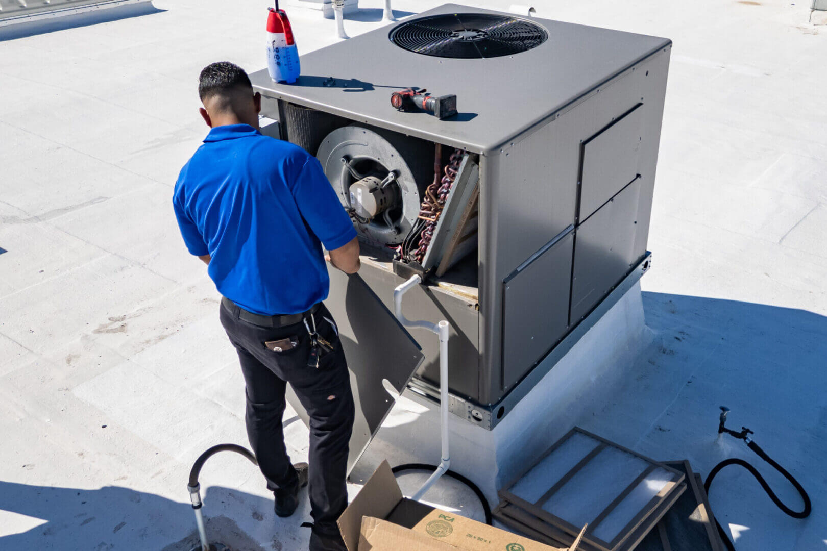 Man servicing rooftop air conditioner